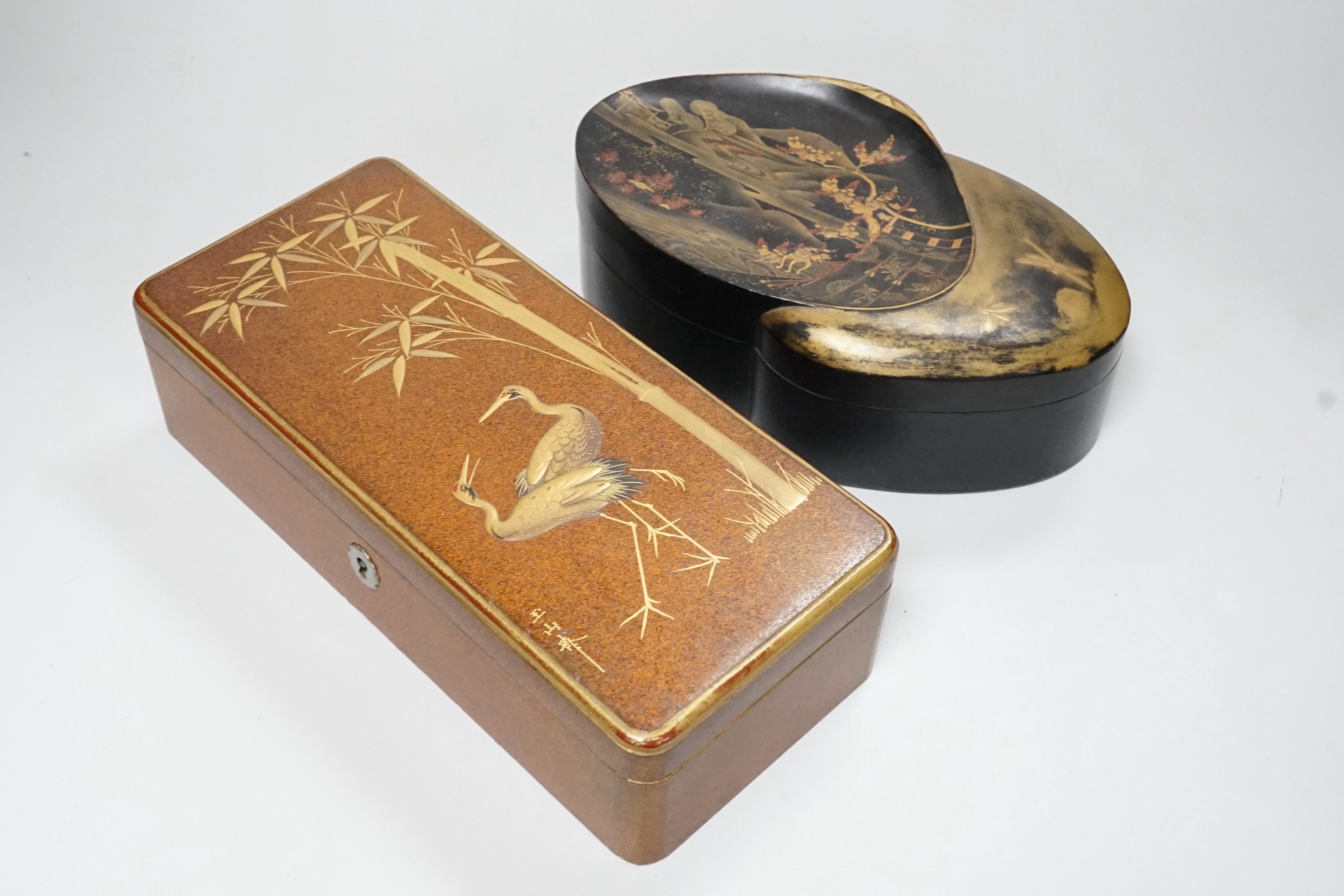 A Japanese lacquer rectangular box and cover, signed, Taisho period and a Japanese clam-shell shaped lacquer box and cover, Meiji period, largest 26cm wide (2)